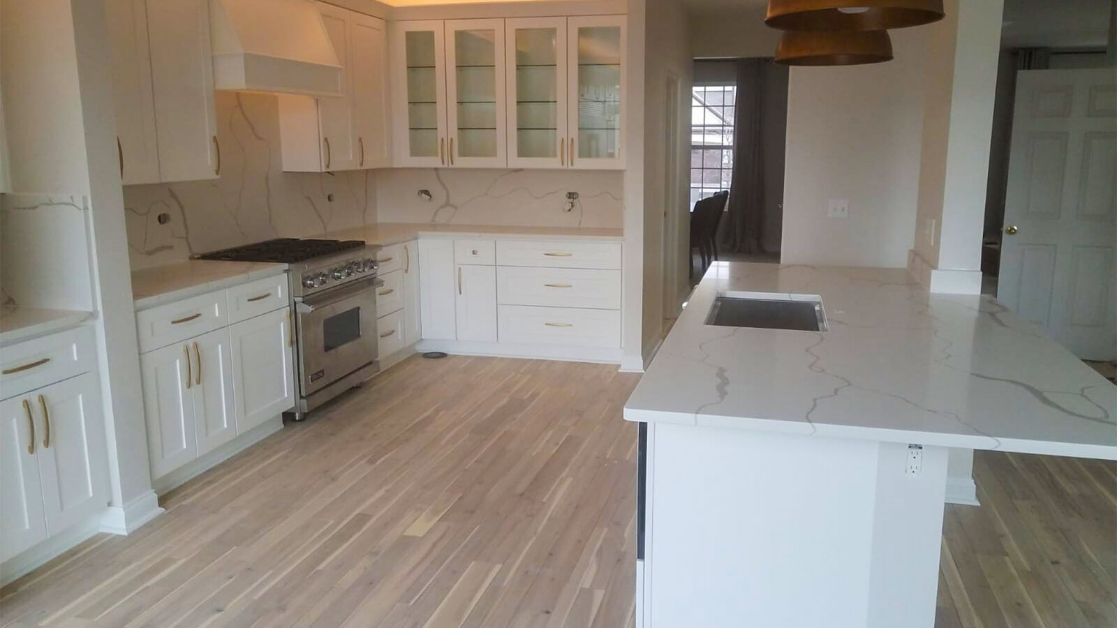 Finished white kitchen remodel with island and new flooring