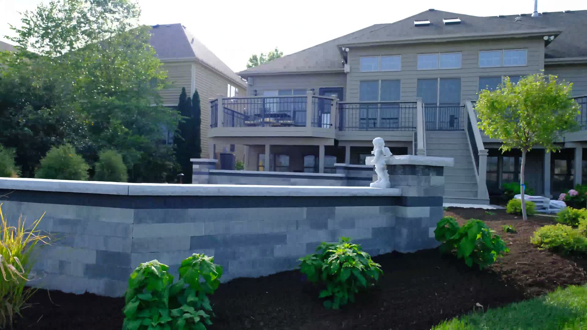 Paver patio with retaining wall and planting beds